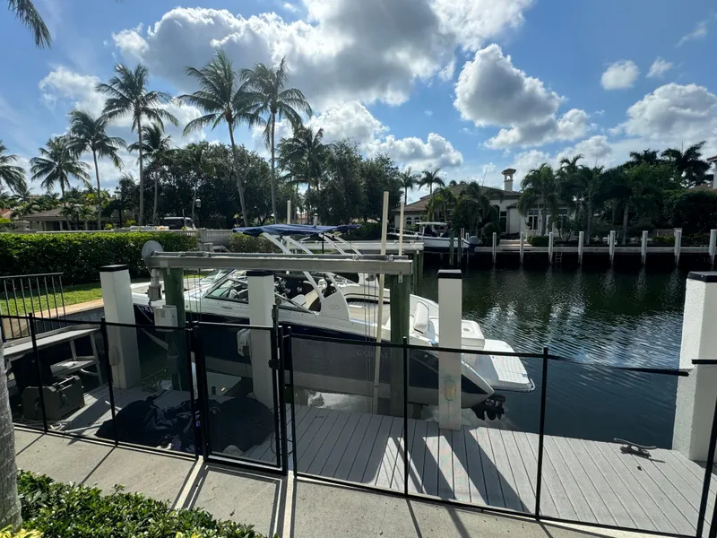 Slide: The Image of Cobalt R7 2015 boat docked by a canal with palm trees and blue sky. - 24
