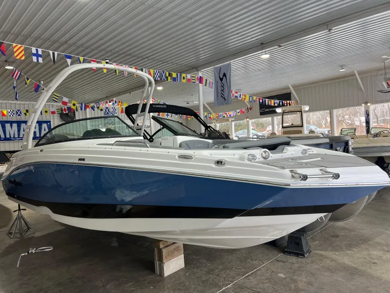 Slide: The Image of 2025 NauticStar 243 DC Deck boat in showroom, blue and white exterior. - 4