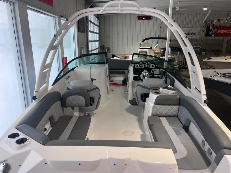 Slide: The Image of 2025 NauticStar 243 DC Deck boat interior with gray seating and modern dashboard. - 7