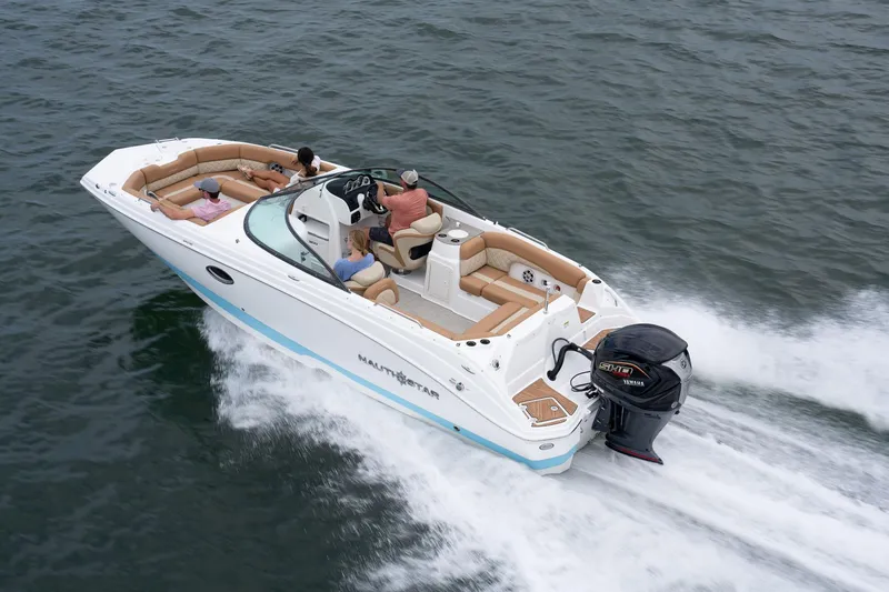 Slide: The Image of 2025 NauticStar 243 DC Deck boat cruising on open water. - 9