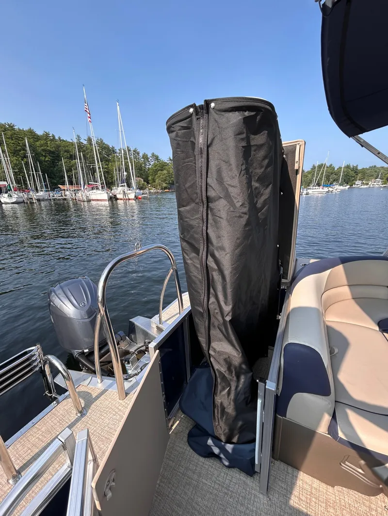 Slide: The Image of 2024 Avalon LSZ Cruise 25' pontoon boat docked by a scenic lake. - 10