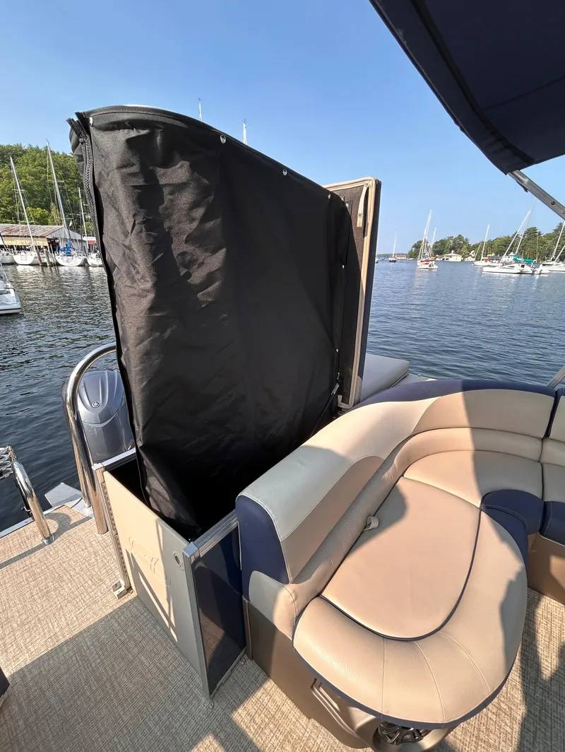 Slide: The Image of 2024 Avalon LSZ Cruise 25' boat with seating and privacy curtain on a sunny day. - 11