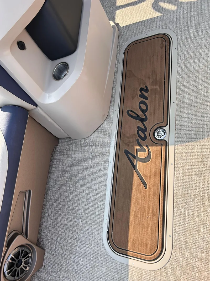 Slide: The Image of 2024 Avalon LSZ Cruise 25' boat interior with wood paneling and logo. - 17