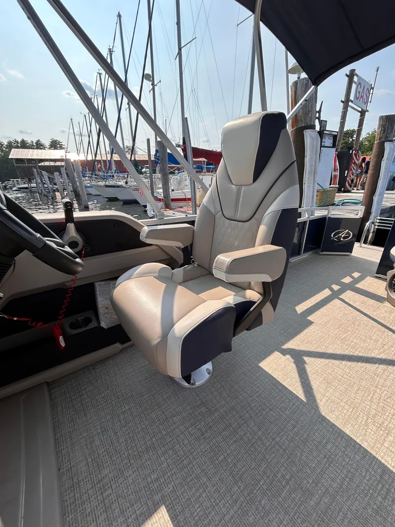 Slide: The Image of 2024 Avalon LSZ Cruise 25' boat captain's chair with marina backdrop. - 20
