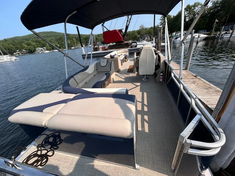 Slide: The Image of 2024 Avalon LSZ Cruise 25' pontoon boat docked at a scenic lake. - 5