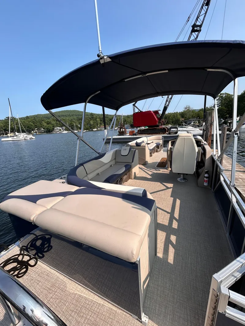 Slide: The Image of 2024 Avalon LSZ Cruise 25' pontoon boat with spacious seating and canopy on a serene lake. - 6