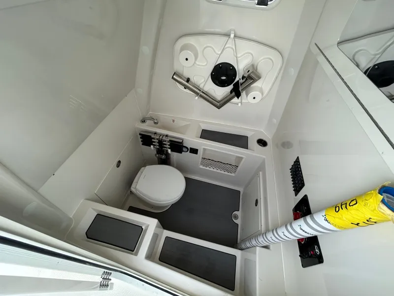 Slide: The Image of 2025 Sailfish 312 CC boat interior with compact bathroom and storage. - 10