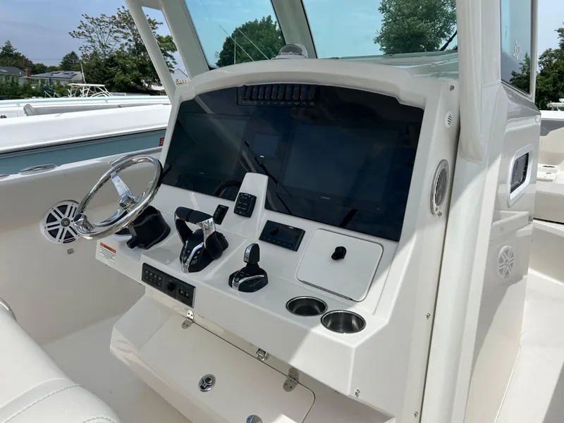 Slide: The Image of 2025 Sailfish 312 CC boat dashboard with modern controls and steering wheel. - 12