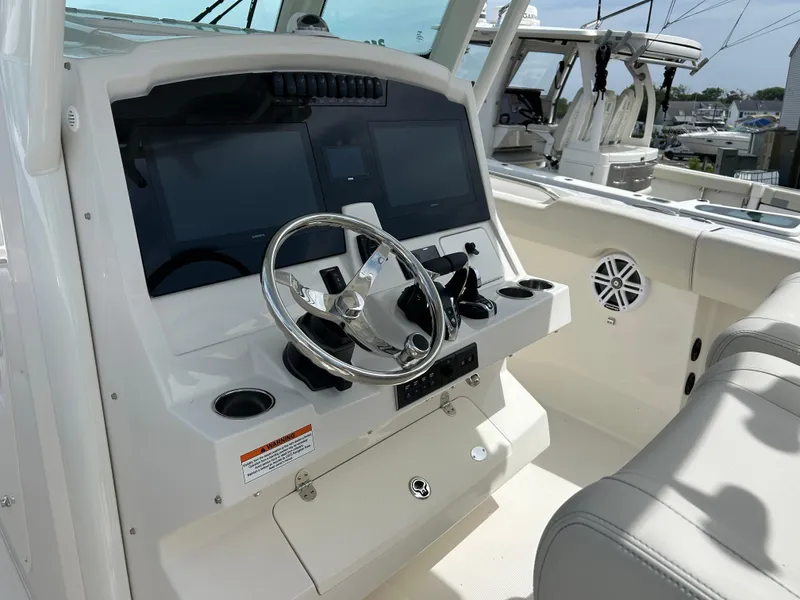 Slide: The Image of 2025 Sailfish 312 CC boat dashboard with steering wheel and dual screens. - 13
