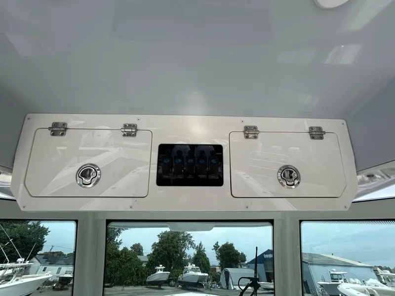 Slide: The Image of 2025 Sailfish 312 CC boat interior storage compartments and control panel. - 14