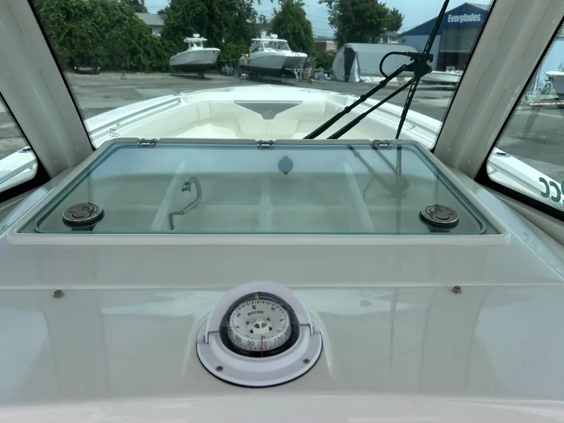 Slide: The Image of 2025 Sailfish 312 CC boat dashboard with compass and storage compartment. - 15