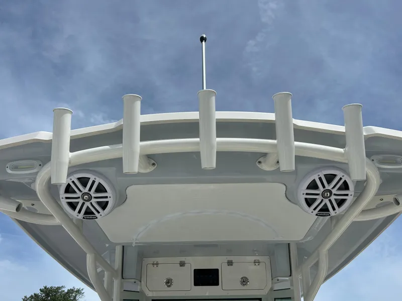 Slide: The Image of 2025 Sailfish 312 CC boat roof with speakers and rod holders against blue sky. - 19