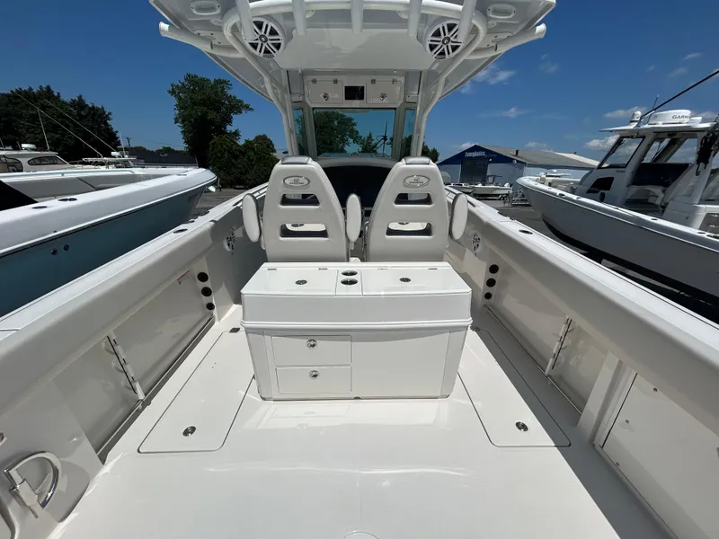 Slide: The Image of 2025 Sailfish 312 CC boat interior with dual seats and storage, docked under clear skies. - 22
