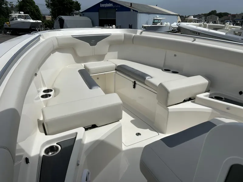 Slide: The Image of 2025 Sailfish 312 CC boat interior with white cushioned seating and cup holders. - 9