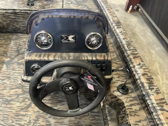Slide: The Image of 2025 Xpress XP170 boat dashboard with camo design and steering wheel. - 11