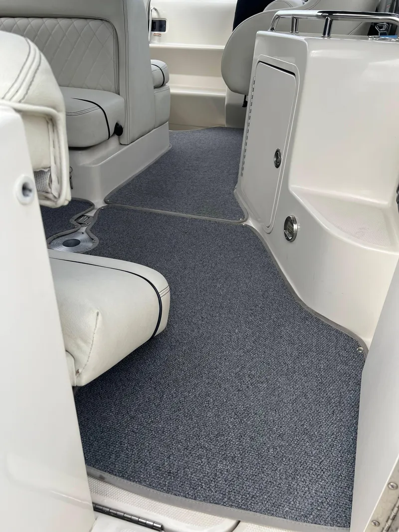 Slide: The Image of Interior of 2000 Sea Ray 240 Sundancer boat with gray carpet and white seating. - 2