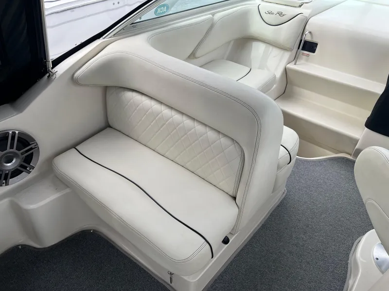 Slide: The Image of Interior seating of 2000 Sea Ray 240 Sundancer with white upholstery and speaker. - 6