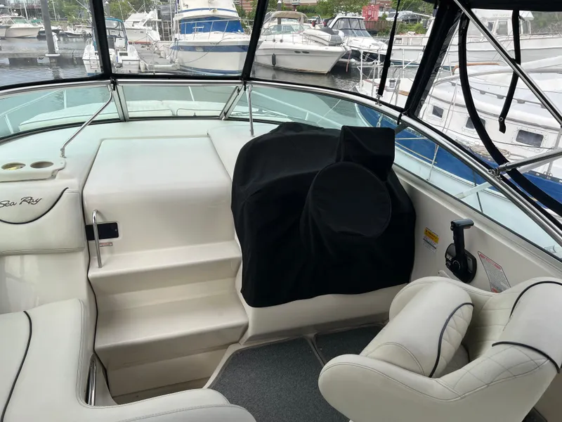 Slide: The Image of 2000 Sea Ray 240 Sundancer interior with helm, seating, and marina view. - 7