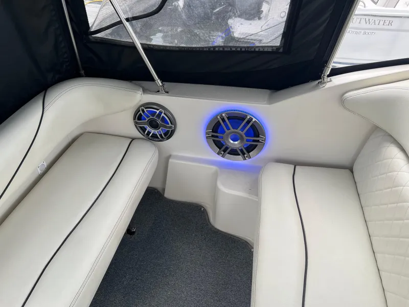 Slide: The Image of Interior of 2000 Sea Ray 240 Sundancer with cushioned seating and illuminated speakers. - 8