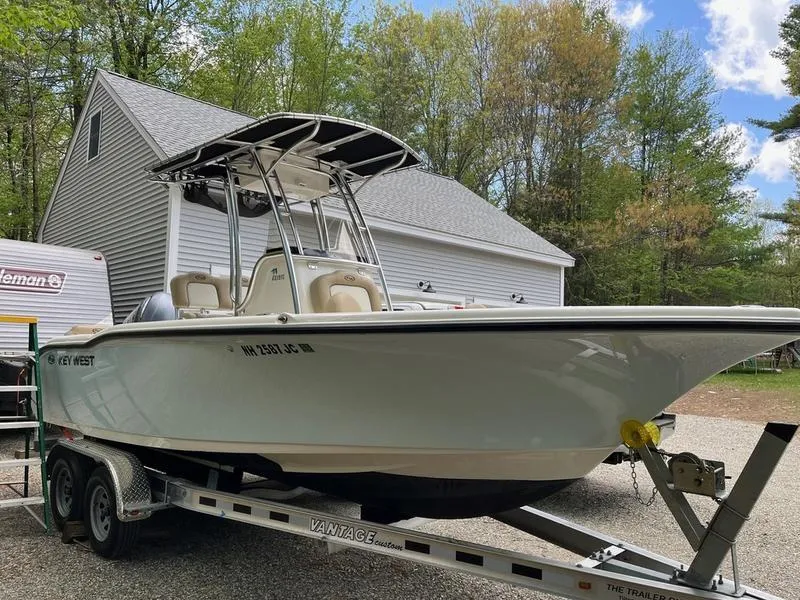 Slide: The Image of 2020 Key West 219fs boat on trailer, parked near a garage in a wooded area. - 10