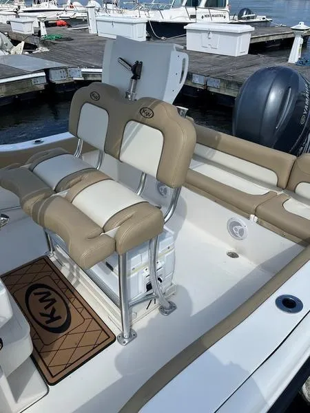 Slide: The Image of 2020 Key West 219fs boat interior with beige seating at a marina. - 3