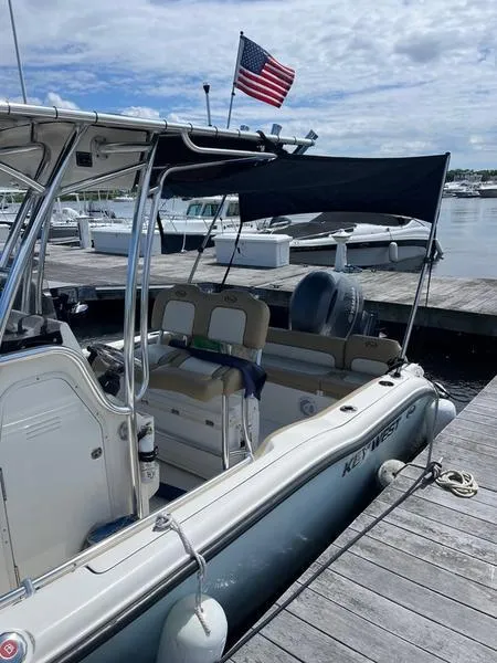 Slide: The Image of 2020 Key West 219fs boat docked with American flag, under cloudy sky. - 8