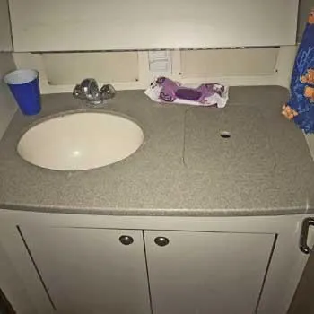 Slide: The Image of 1999 Hunter 380 boat bathroom sink with faucet and storage cabinet. - 15