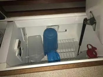 Slide: The Image of Storage compartment in a 1999 Hunter 380 sailboat with containers and a hydraulic support. - 17