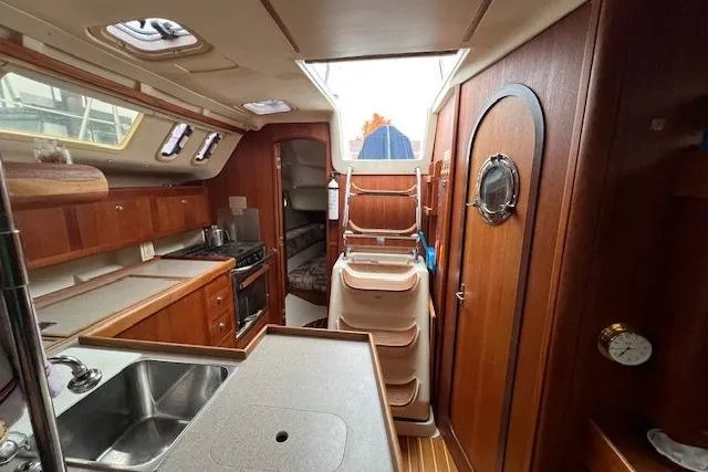 Slide: The Image of Interior of 1999 Hunter 380 sailboat with wood finish and compact kitchen area. - 18