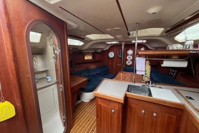 Slide: The Image of Interior of a 1999 Hunter 380 sailboat with wooden cabinetry and cozy seating. - 19