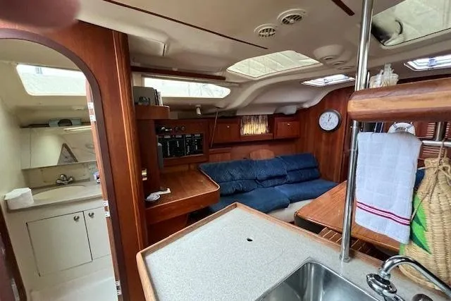 Slide: The Image of Interior of a 1999 Hunter 380 sailboat with cozy seating and wooden cabinetry. - 23