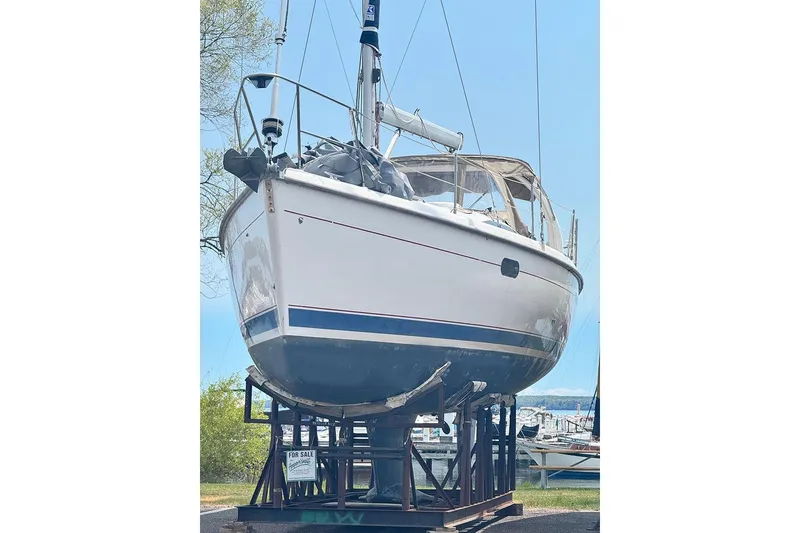 Slide: The Image of 1999 Hunter 380 sailboat on display, elevated on a stand, with a "For Sale" sign. - 26