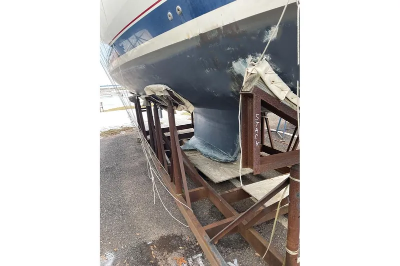 Slide: The Image of 1999 Hunter 380 sailboat on stands, showing hull and keel in a boatyard. - 32