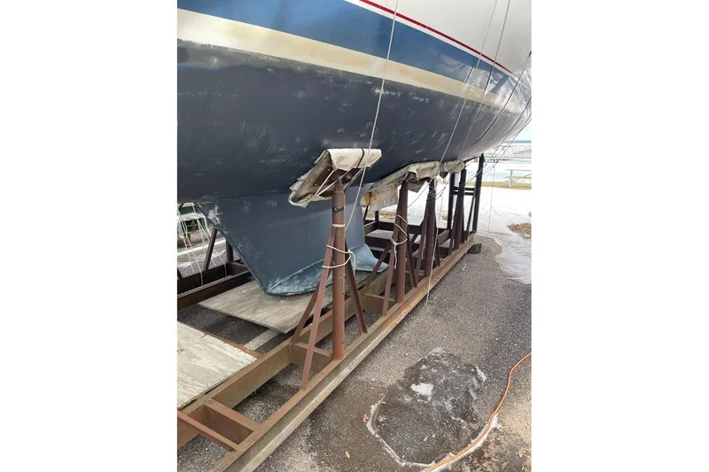Slide: The Image of 1999 Hunter 380 sailboat on stands, showing hull and keel in a boatyard. - 33