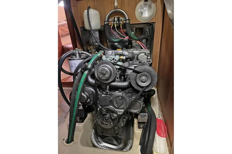 Slide: The Image of Engine of a 1999 Hunter 380 sailboat, showcasing mechanical components and hoses. - 39