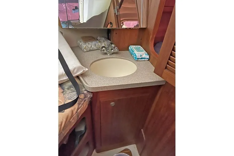 Slide: The Image of 1999 Hunter 380 yacht interior with sink, wooden cabinetry, and mirror. - 42