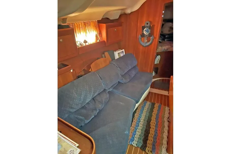 Slide: The Image of Interior of 1999 Hunter 380 sailboat with blue sofa and wooden accents. - 43