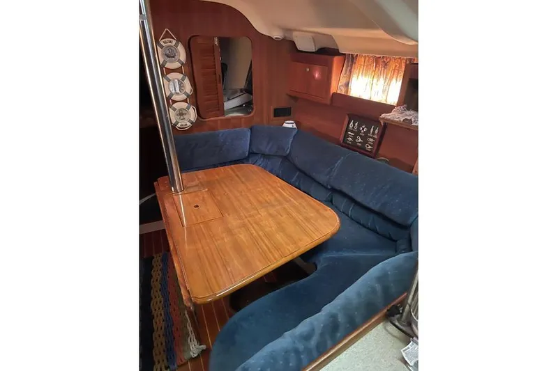 Slide: The Image of Interior of 1999 Hunter 380 sailboat with wooden table and blue cushioned seating. - 44