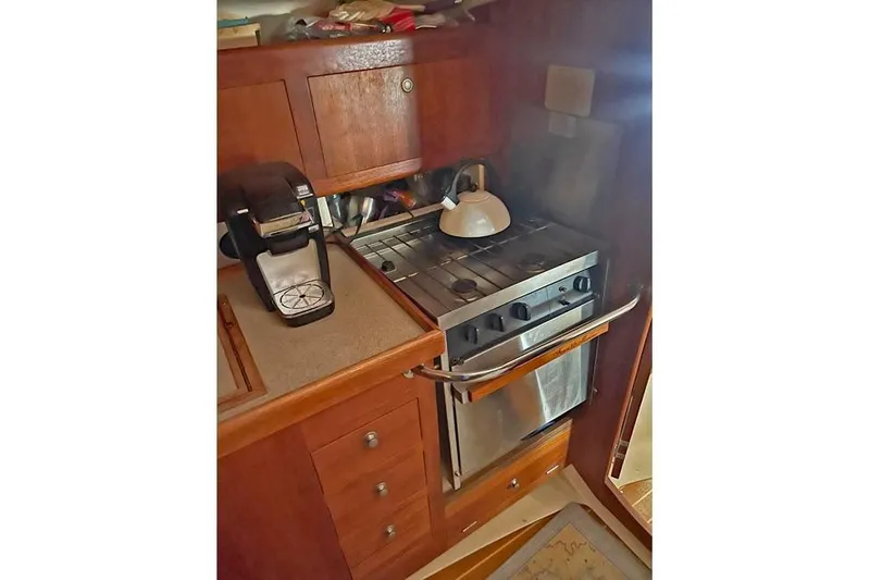 Slide: The Image of Compact kitchen in a 1999 Hunter 380 sailboat with stove, kettle, and coffee maker. - 47