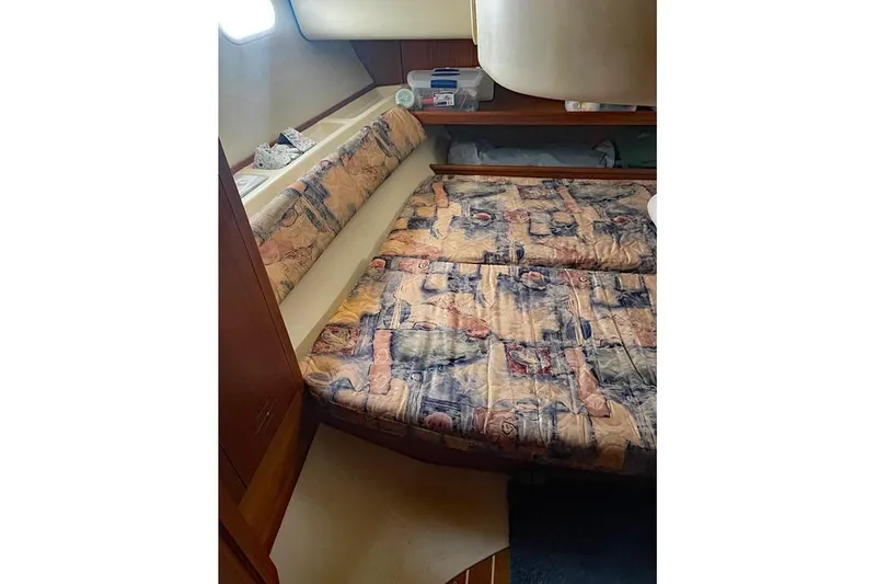 Slide: The Image of 1999 Hunter 380 sailboat interior cabin with patterned bedding and wooden accents. - 48