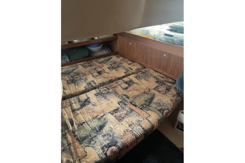 Slide: The Image of Interior cabin of 1999 Hunter 380 sailboat with patterned bedding and wooden storage. - 49