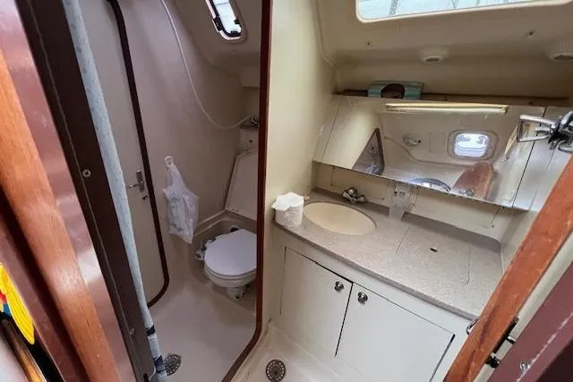 Slide: The Image of 1999 Hunter 380 yacht bathroom with sink, mirror, and toilet. - 52