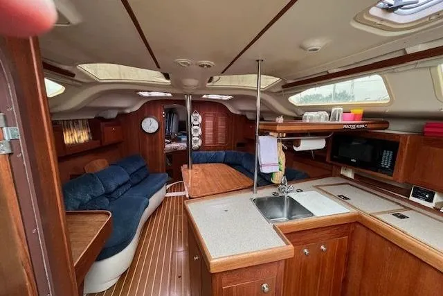 Slide: The Image of Interior of a 1999 Hunter 380 sailboat with wood finish and cozy seating area. - 53