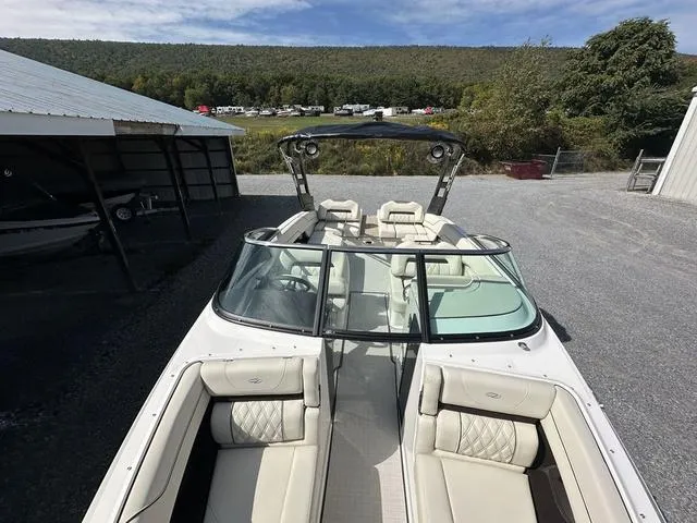 Slide: The Image of 2025 Regal LS6 boat with luxurious seating, parked outdoors near a scenic landscape. - 23