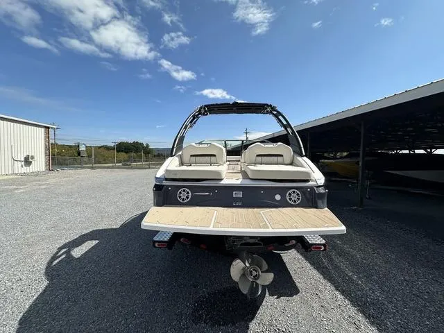 Slide: The Image of 2025 Regal LS6 boat, rear view, parked outdoors under clear sky. - 7