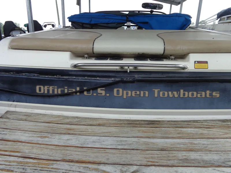 Slide: The Image of 1998 Malibu Sunsetter VLX boat, labeled "Official U.S. Open Towboats," docked with blue cover. - 11
