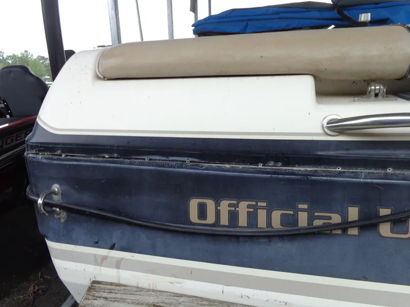 Slide: The Image of 1998 Malibu Sunsetter VLX boat with "Official" lettering, docked under shelter. - 12