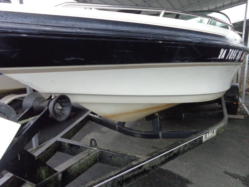 Slide: The Image of 1998 Malibu Sunsetter VLX boat on trailer, black and white hull, parked under shelter. - 19