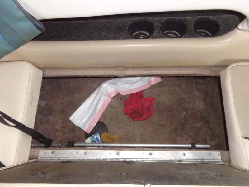 Slide: The Image of Interior of a 1998 Malibu Sunsetter VLX boat with cup holders and scattered items. - 38