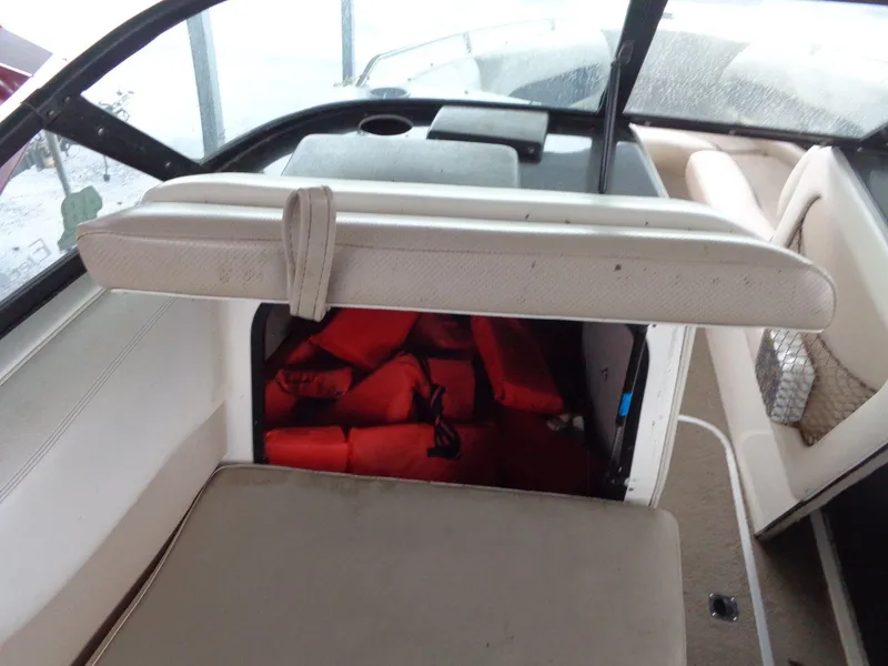 Slide: The Image of 1998 Malibu Sunsetter VLX boat interior with storage compartment and life jackets. - 42